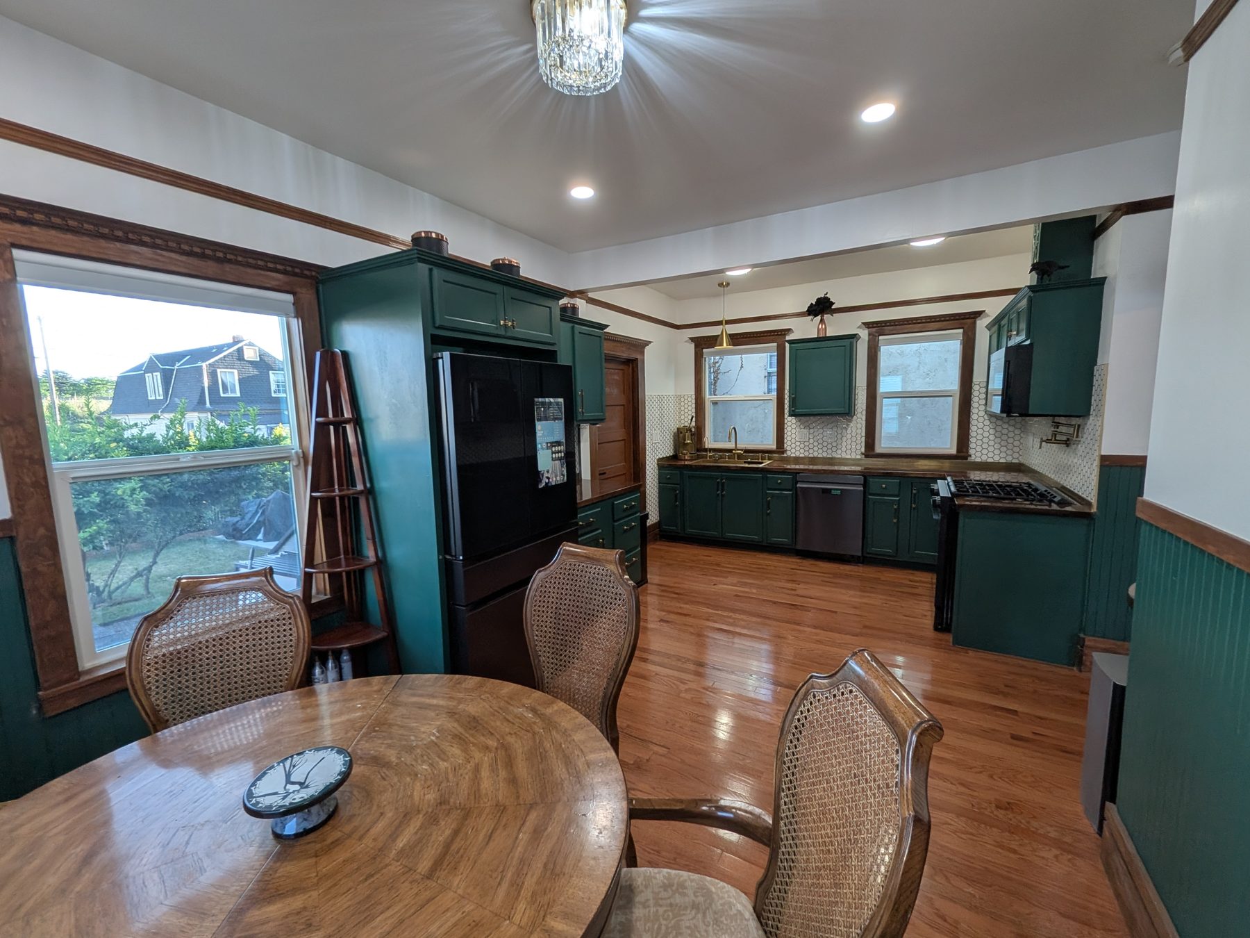 Eat-in kitchen with forest-green cabinetry and dining area