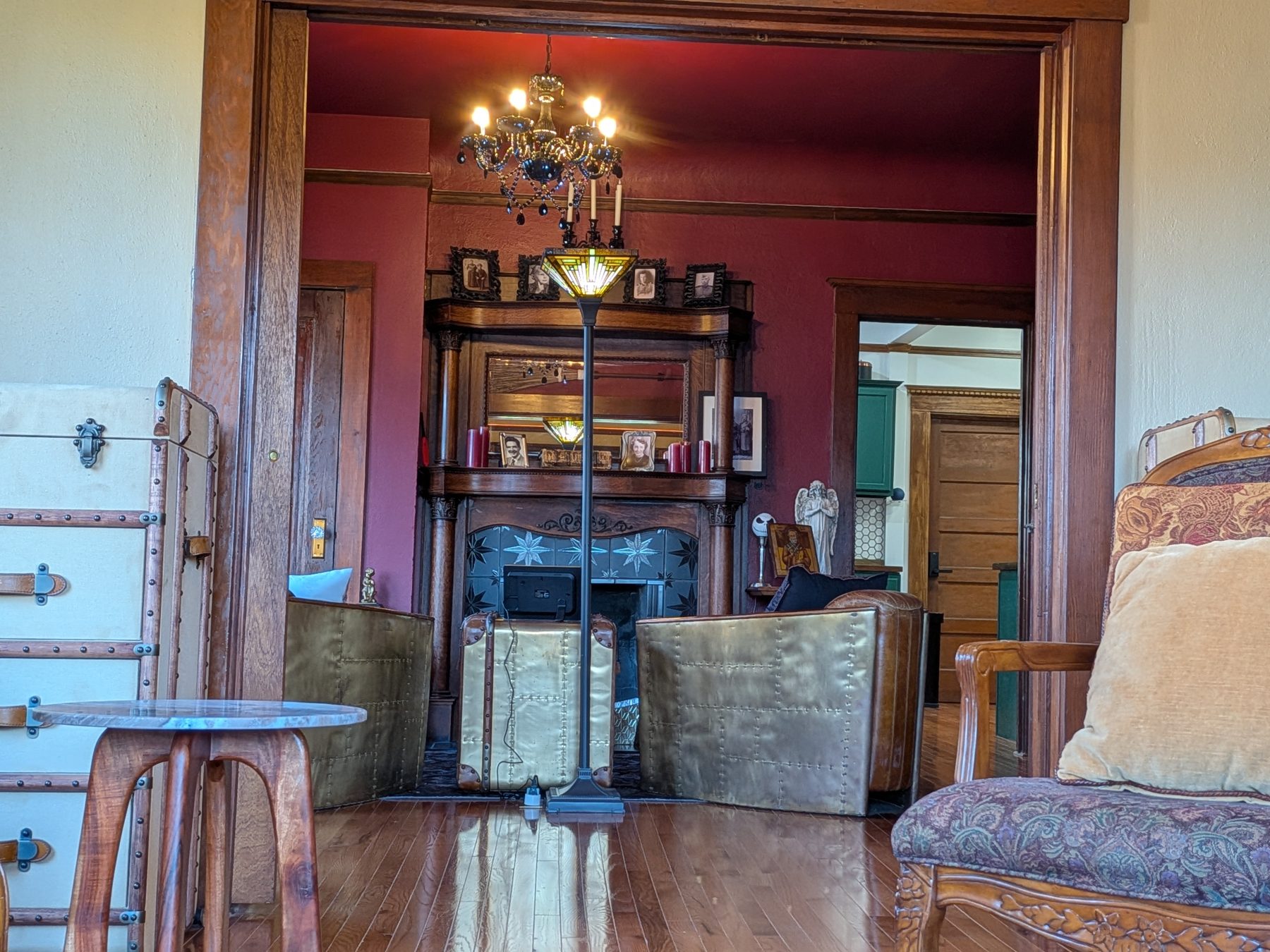 The library and parlor with original carved-wood fireplace mantel and decorative tile surround
