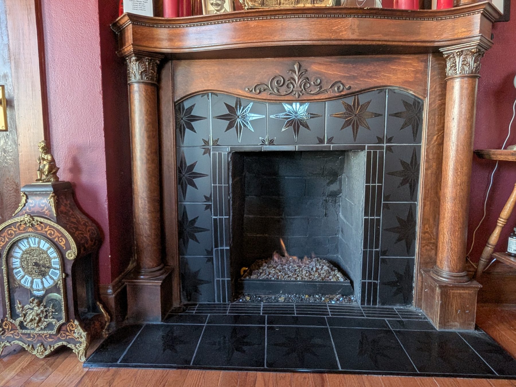 Original carved-wood fireplace mantel with decorative tile surround